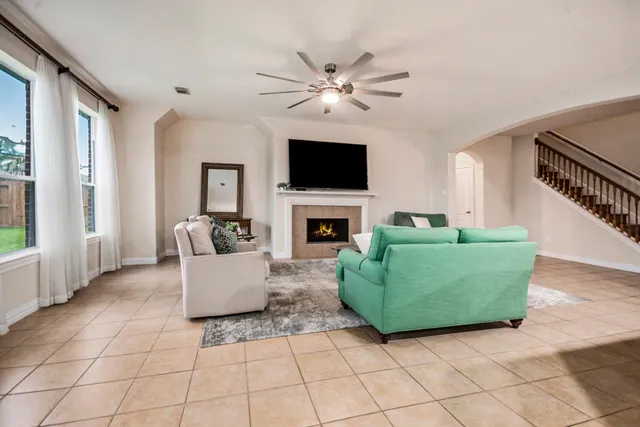 a living room with furniture a flat screen tv and a fireplace