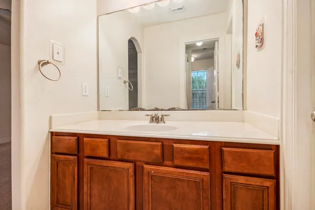 an empty room with a chandelier fan and windows