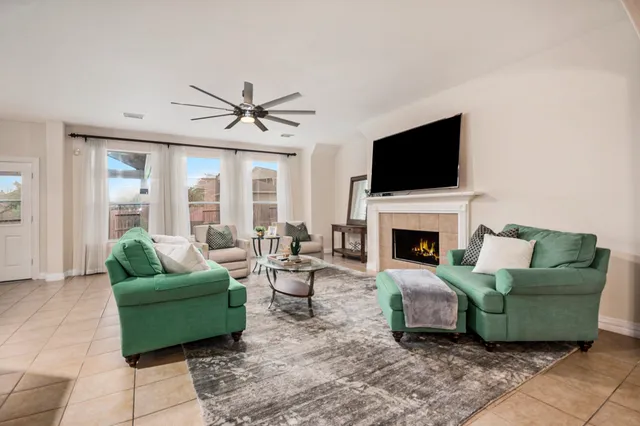 a living room with furniture a flat screen tv and a fireplace