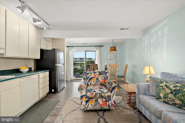 a kitchen with granite countertop white cabinets white stainless steel appliances and a refrigerator