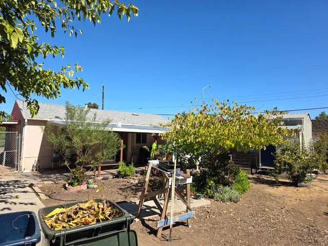 a backyard of a house with table and chairs