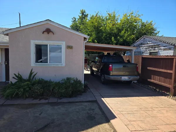 a front view of house with yard space and trees in the background