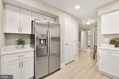 a kitchen with a refrigerator sink and cabinets