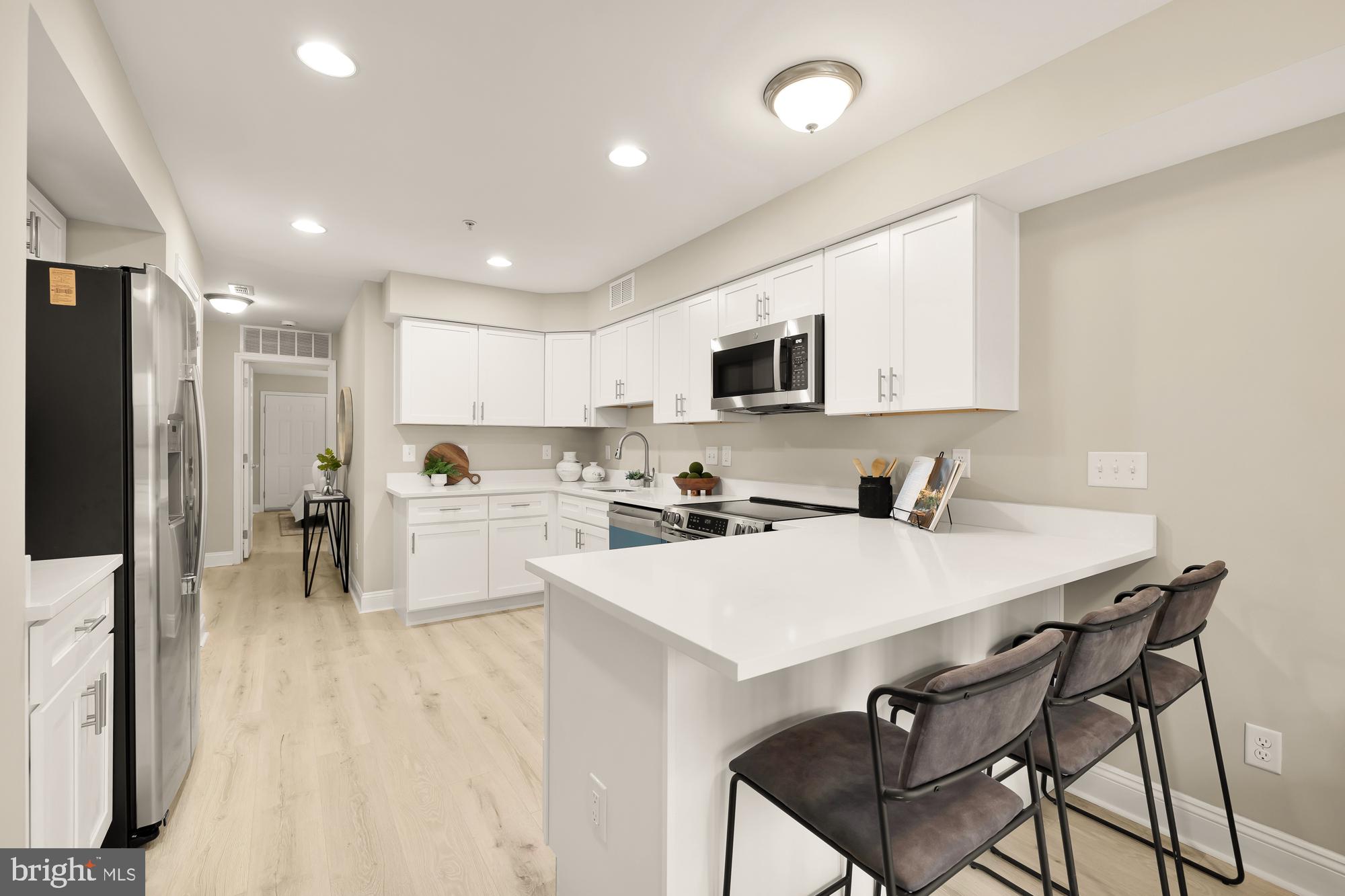 1751 W Street Southeast, Unit B Washington, DC 20020 - Photo 10 of 25 a kitchen with white cabinets and stainless steel appliances
