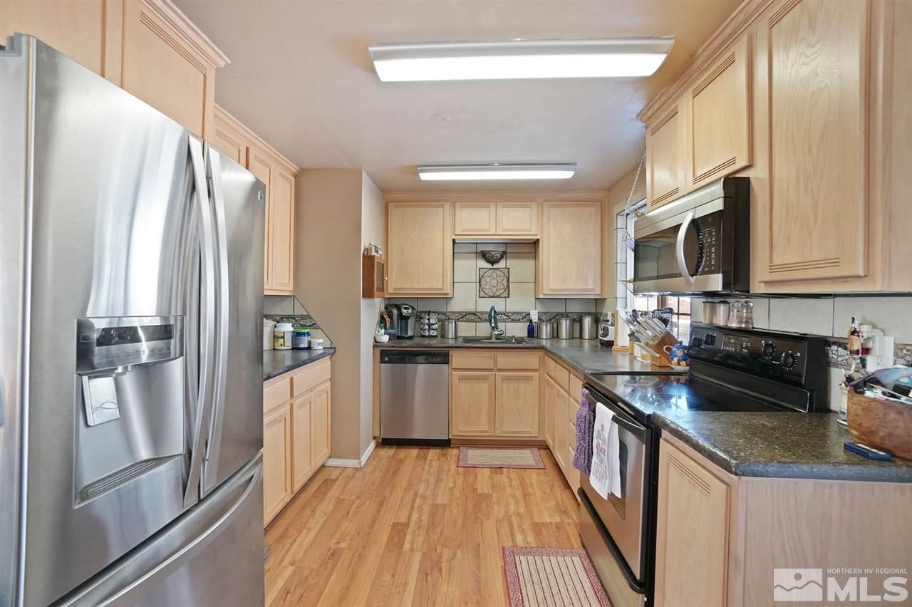 3800 Alcorn Road Fallon, NV 89406 - Photo 5 of 18 a kitchen with stainless steel appliances granite countertop a refrigerator a stove top oven and sink