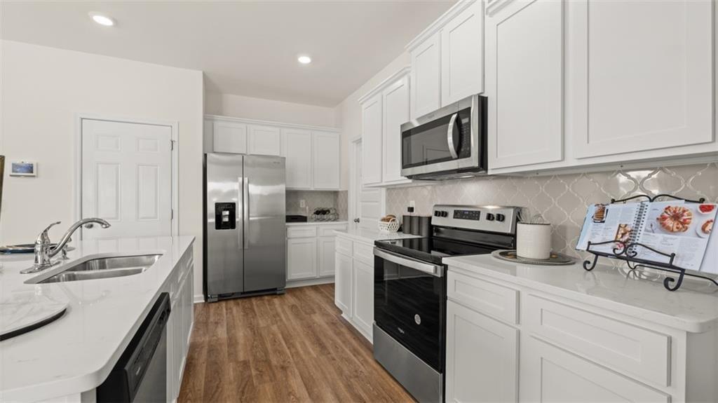 11933 Aukerman Way Hampton, GA 30228 - Photo 12 of 42 a kitchen with granite countertop a refrigerator stove and sink