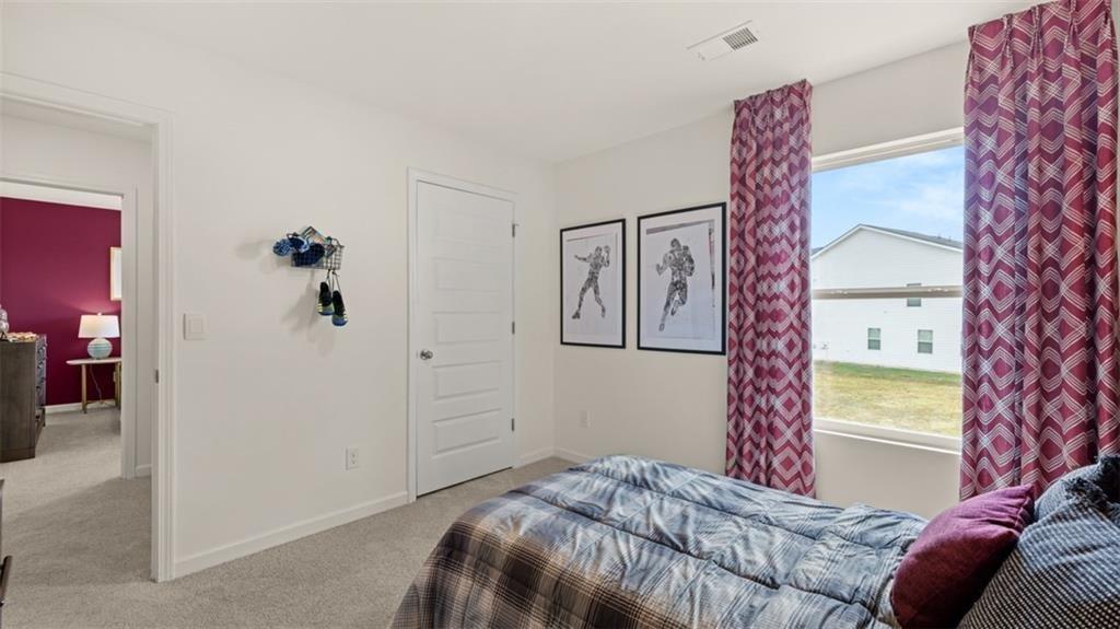 11933 Aukerman Way Hampton, GA 30228 - Photo 36 of 42 a bedroom with a bed and a chandelier