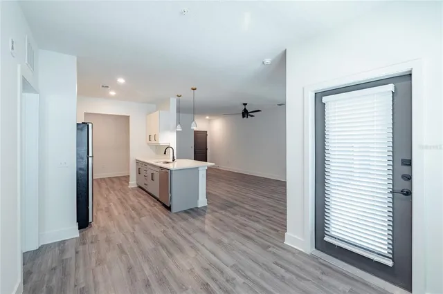 a large kitchen with a wooden floor and stainless steel appliances