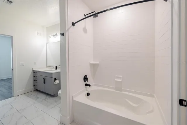 a bathroom with a tub a sink and a mirror