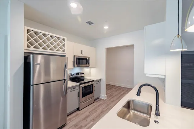 a kitchen with stainless steel appliances granite countertop a refrigerator sink and stove