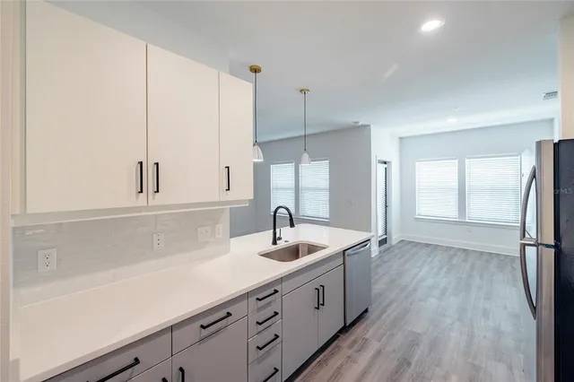 a kitchen with sink refrigerator and window