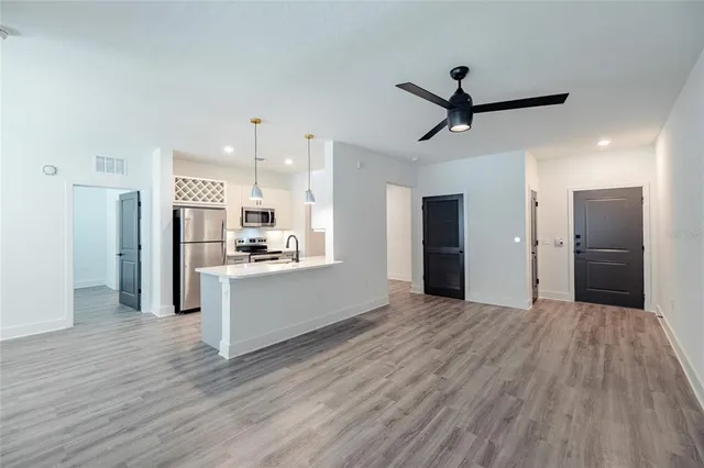 a view of a kitchen with refrigerator and wooden floor