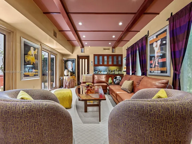 a living room with patio furniture and a large window