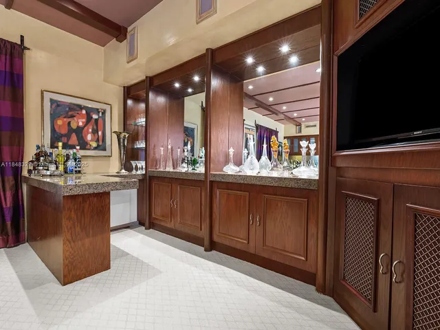 a kitchen with stainless steel appliances kitchen island granite countertop a refrigerator and a wooden cabinets