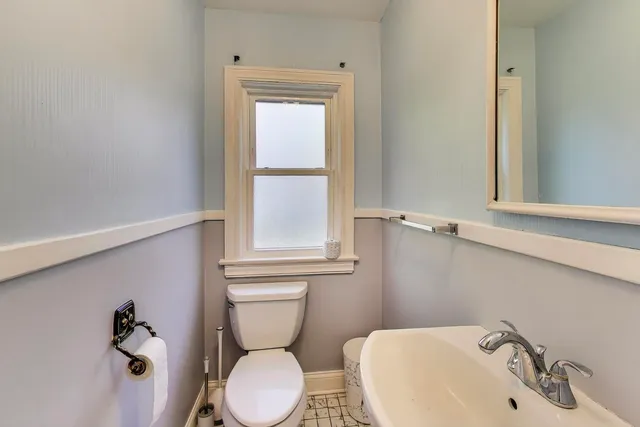 a bathroom with a sink mirror and toilet