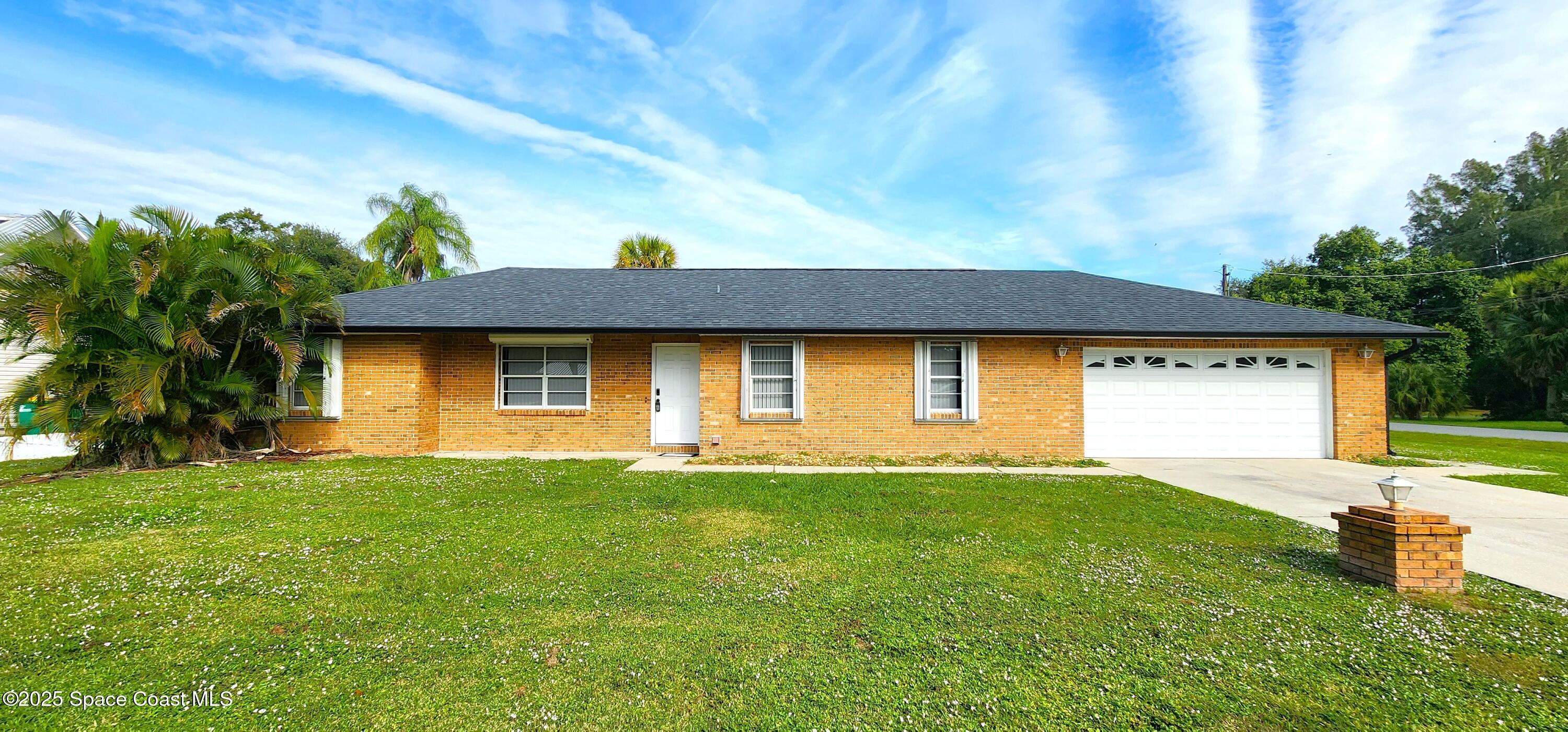 7746 Mango Grove Avenue Melbourne, FL 32904 - Photo 1 of 17 a front view of a house with a yard