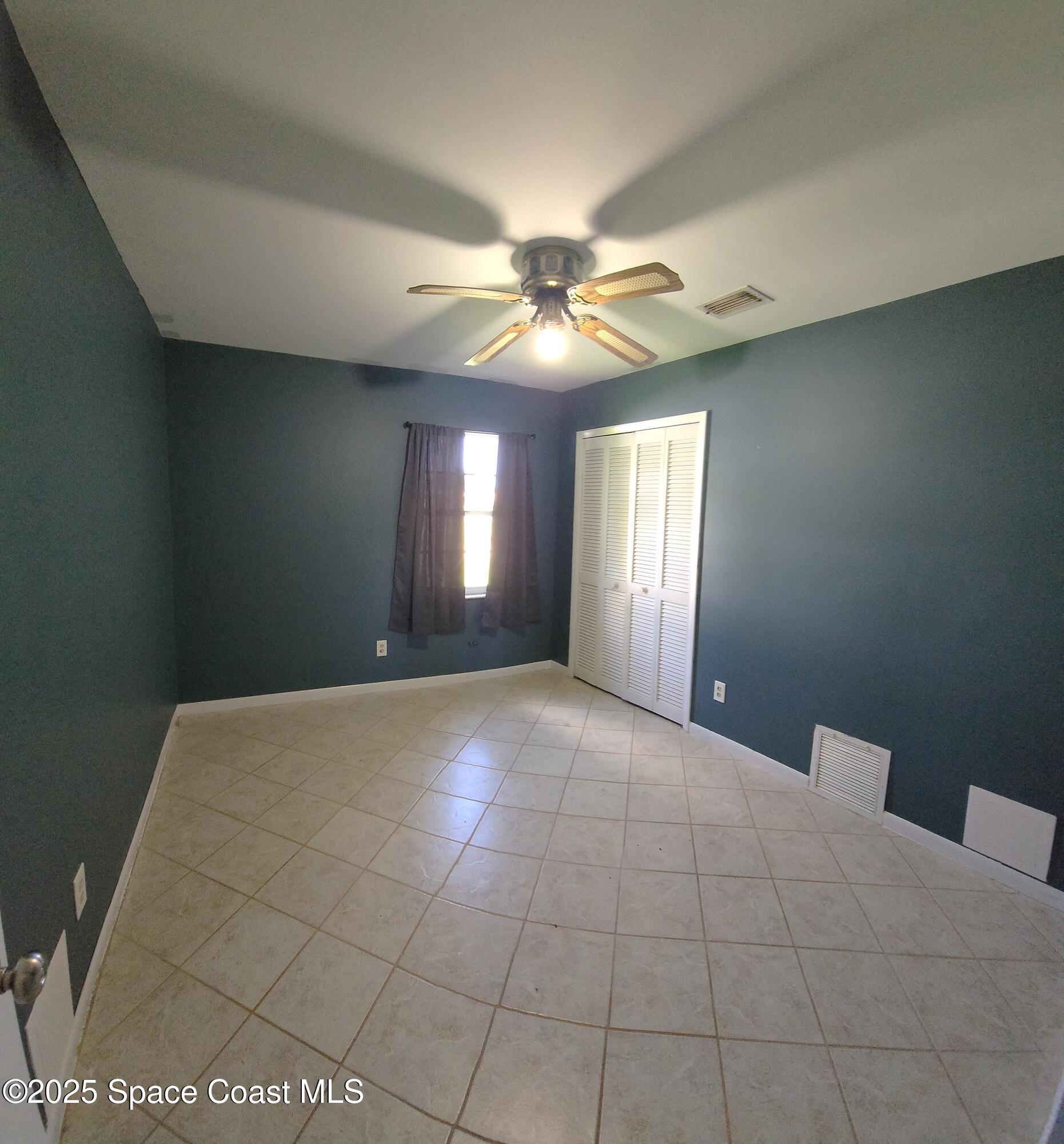 7746 Mango Grove Avenue Melbourne, FL 32904 - Photo 13 of 17 a view of an empty room with window and chandelier fan