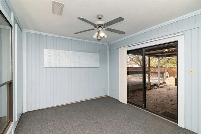 a view of an empty room with a ceiling fan and window