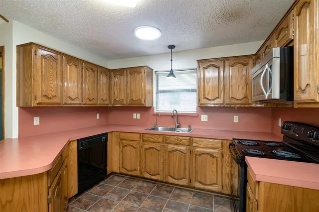 a kitchen with stainless steel appliances granite countertop a sink stove and cabinets