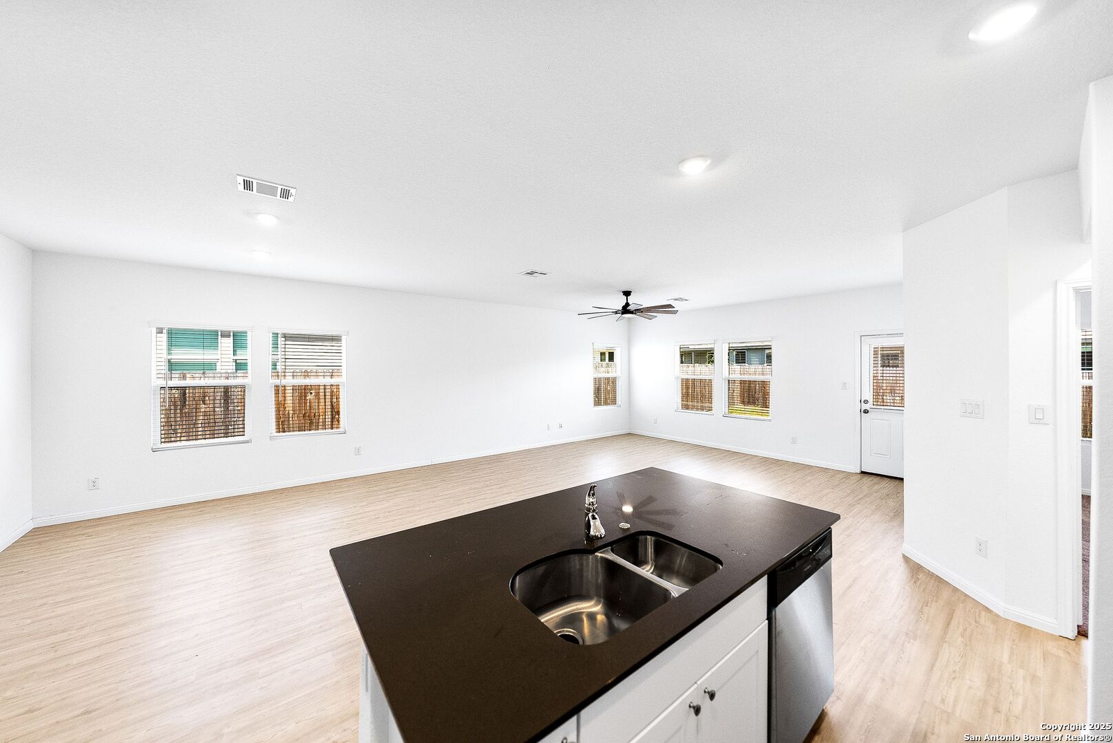 31920 Native Sun Road Bulverde, TX 78163 - Photo 11 of 62 an empty room with wooden floor and black cabinet