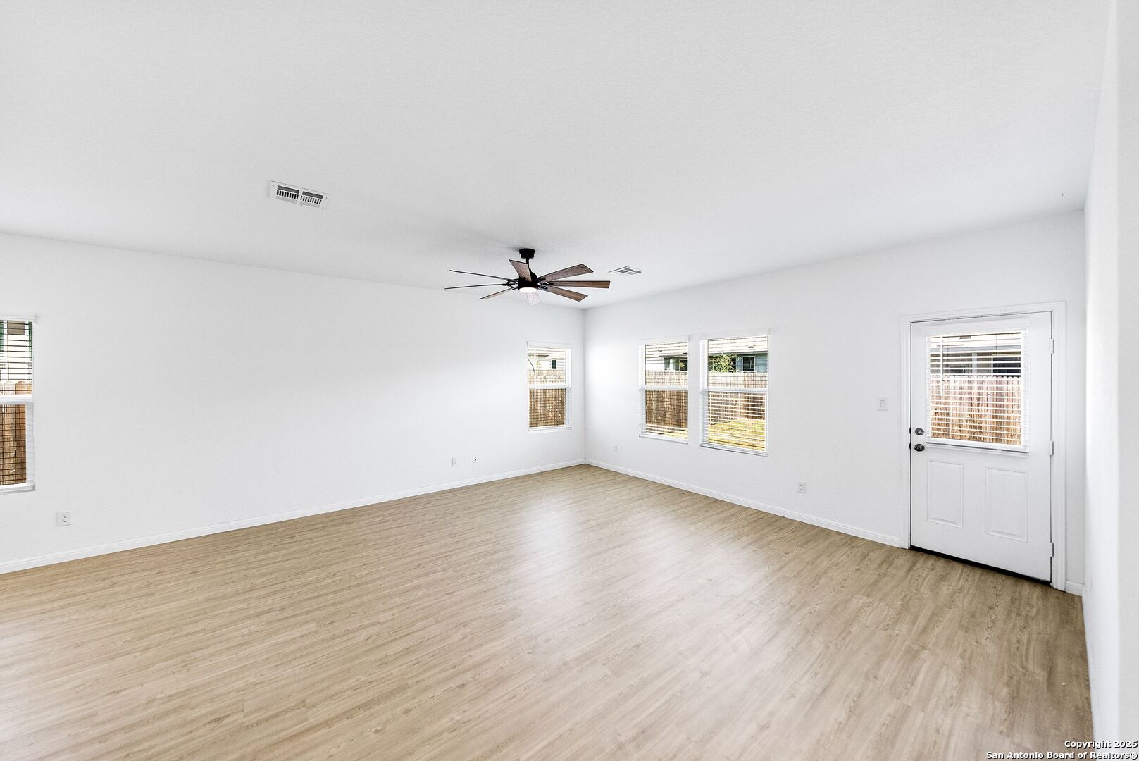 31920 Native Sun Road Bulverde, TX 78163 - Photo 6 of 62 an empty room with wooden floor ceiling fan and windows