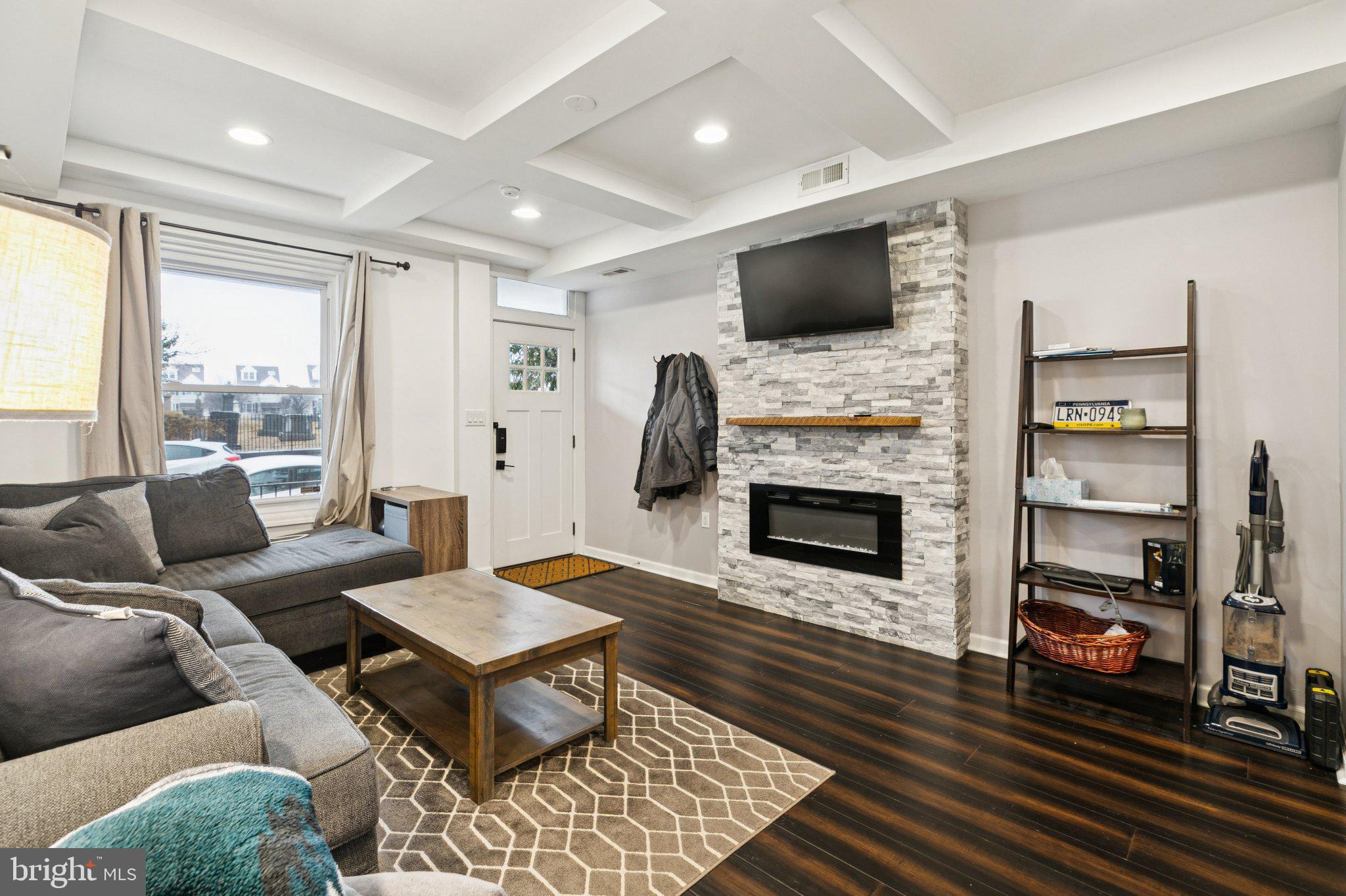 a living room with furniture a fireplace and a flat screen tv