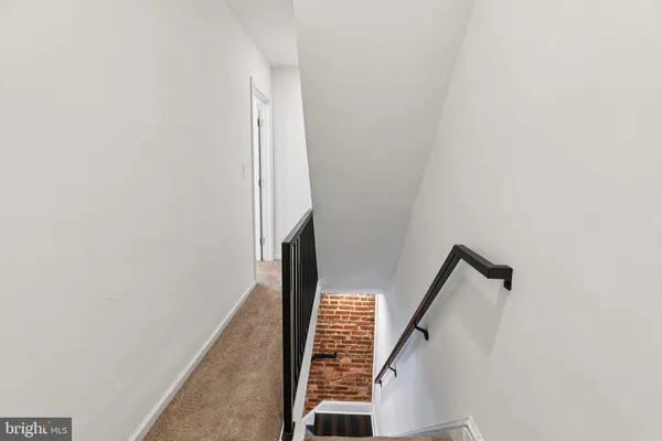 a view of staircase with wooden floor and white walls