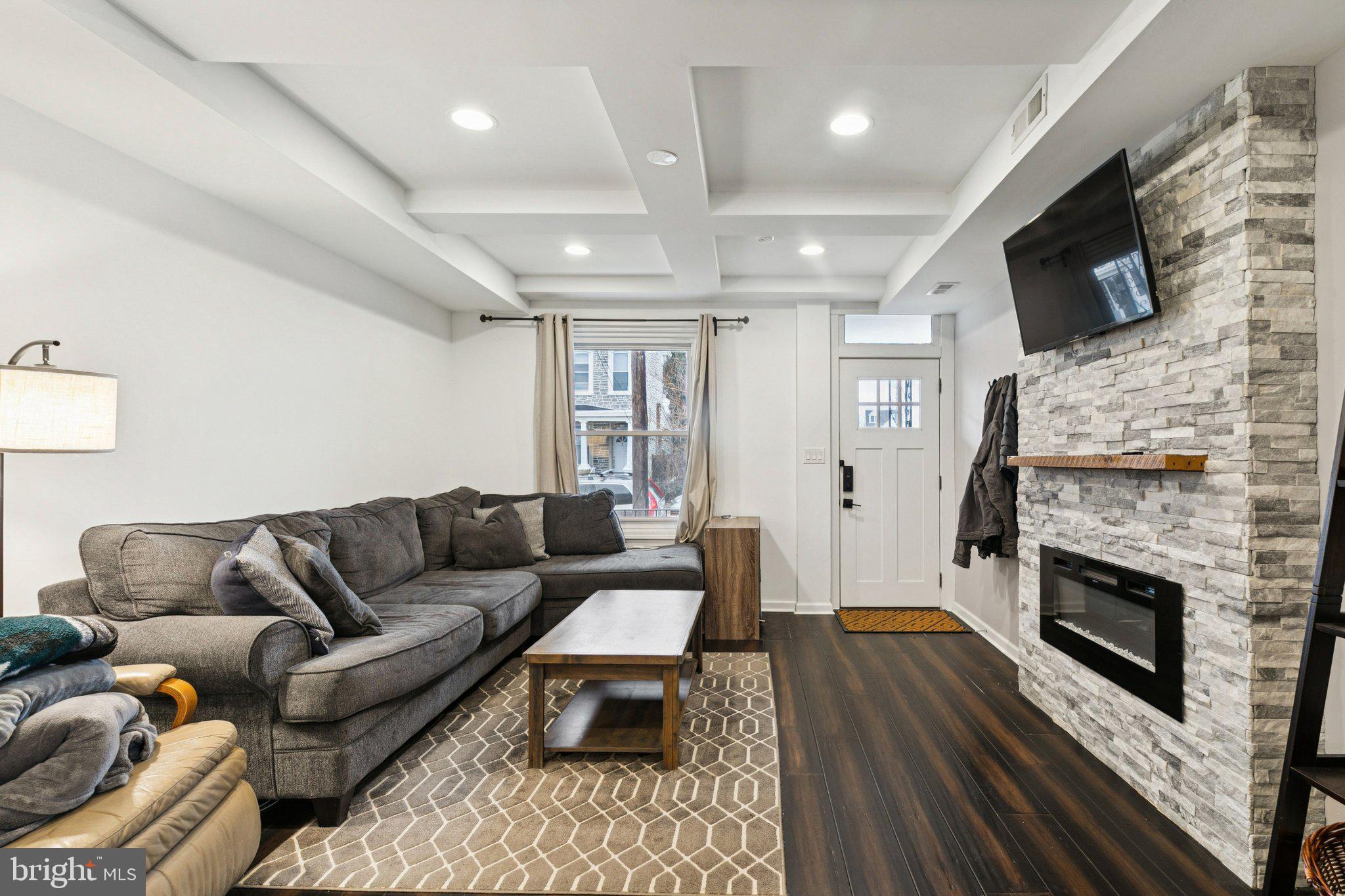 359 Lemonte Street Philadelphia, PA 19128 - Photo 5 of 37 a living room with furniture a flat screen tv and a fireplace