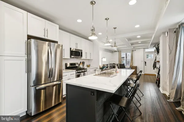 a kitchen with refrigerator a sink and chairs