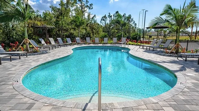 a view of backyard with swimming pool and seating
