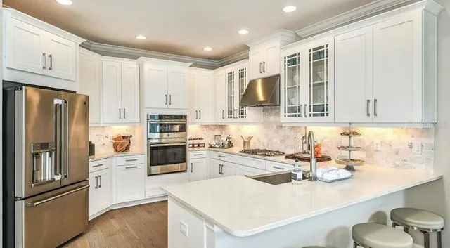 a kitchen with stainless steel appliances kitchen island granite countertop a sink and cabinets