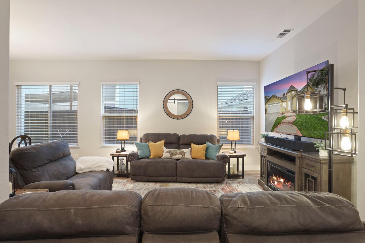 2307 Lighthouse Circle Tracy, CA 95304 - Photo 14 of 57 a living room with furniture a fireplace and a flat screen tv
