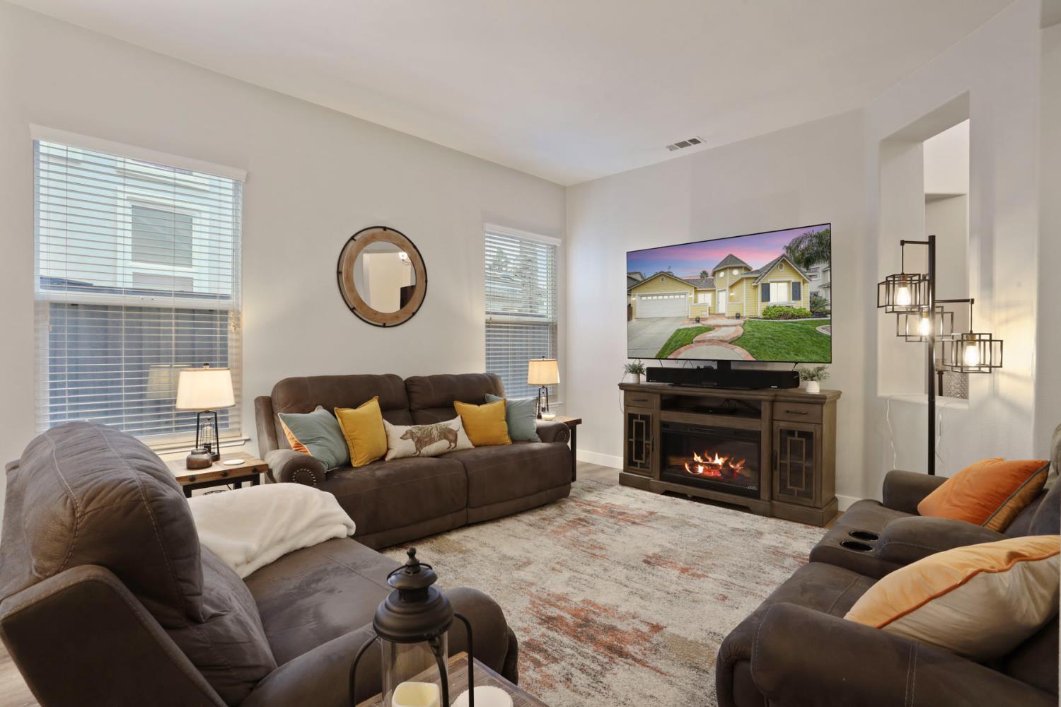 2307 Lighthouse Circle Tracy, CA 95304 - Photo 16 of 57 a living room with furniture a flat screen tv and a fireplace