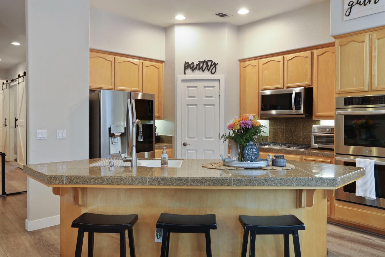 2307 Lighthouse Circle Tracy, CA 95304 - Photo 25 of 57 a kitchen with stainless steel appliances granite countertop a stove refrigerator and microwave