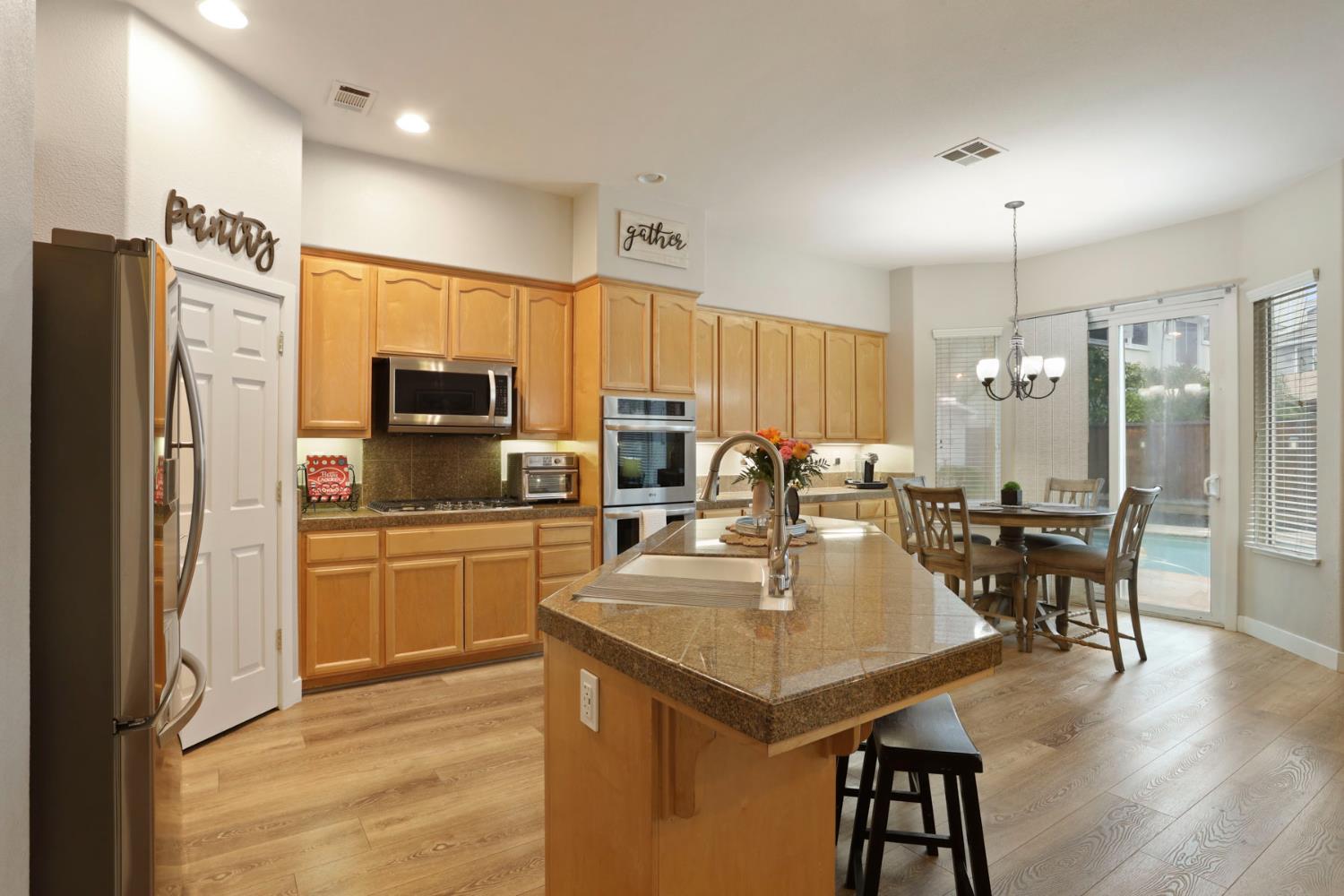 2307 Lighthouse Circle Tracy, CA 95304 - Photo 26 of 57 a kitchen with stainless steel appliances granite countertop a sink a stove a refrigerator cabinets and chairs