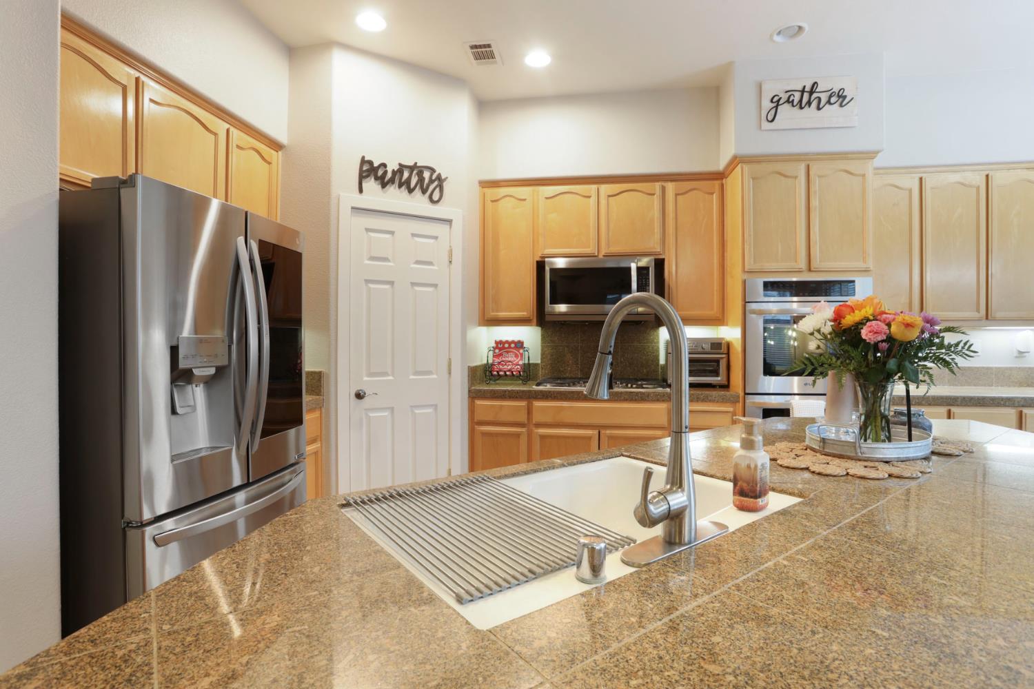 2307 Lighthouse Circle Tracy, CA 95304 - Photo 33 of 57 a kitchen with stainless steel appliances kitchen island granite countertop a refrigerator and a sink