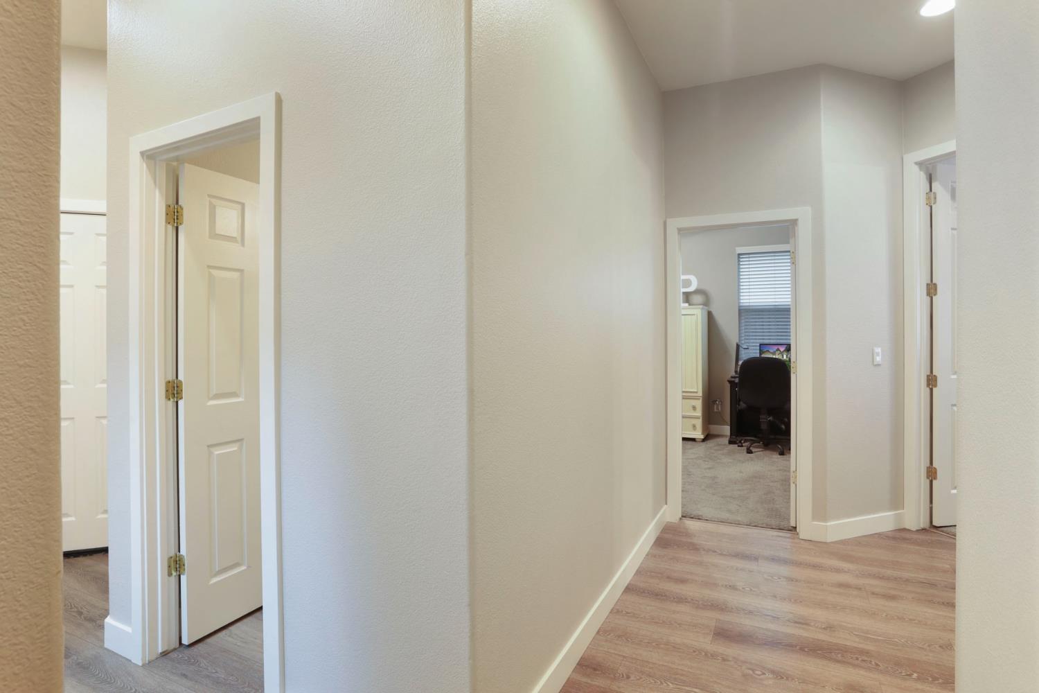 2307 Lighthouse Circle Tracy, CA 95304 - Photo 37 of 57 a view of a hallway with wooden floor and a bathroom