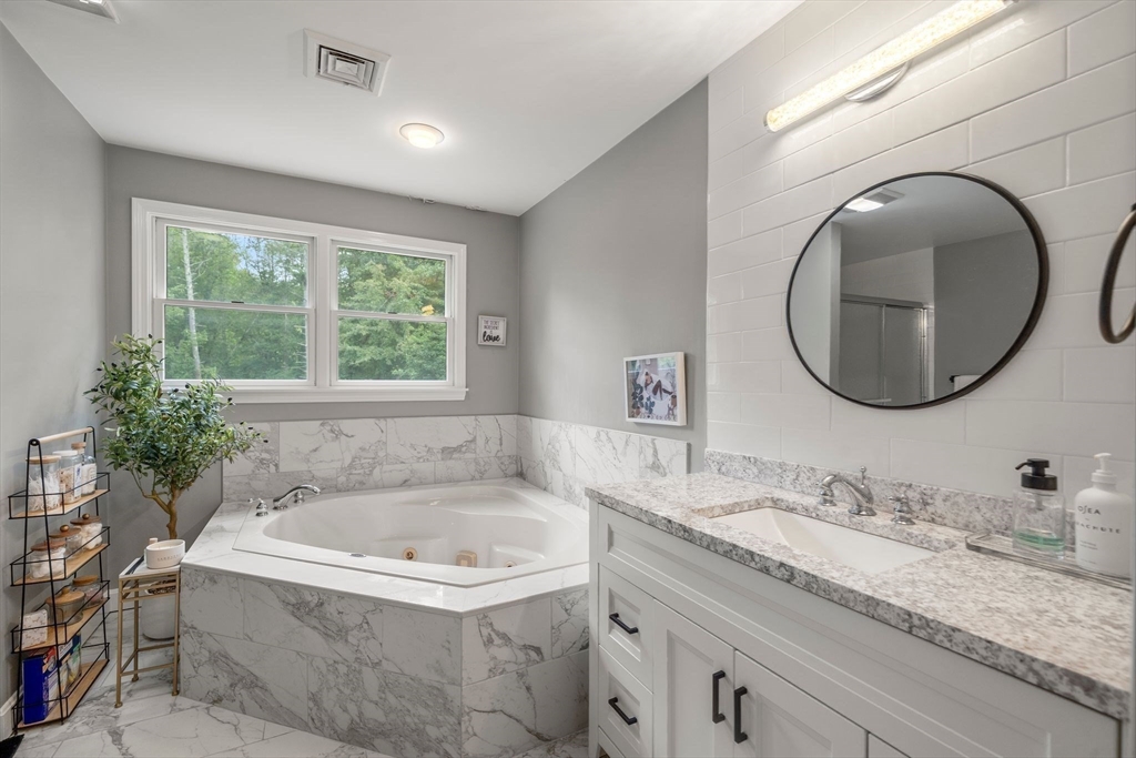 34 Wood Duck Road Acushnet, MA 02743 - Photo 11 of 23 a bathroom with a granite countertop sink mirror and bathtub