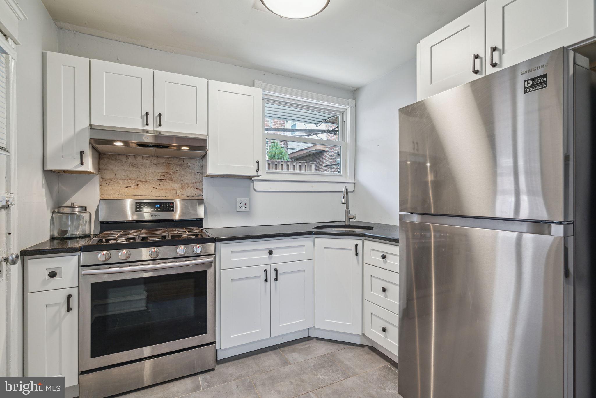 3455 Tilden Street Philadelphia, PA 19129 - Photo 11 of 32 a kitchen with white cabinets and stainless steel appliances