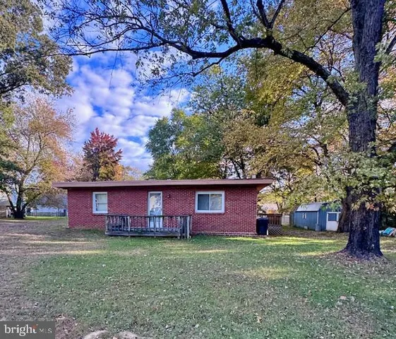 a view of a house with a yard and large trees