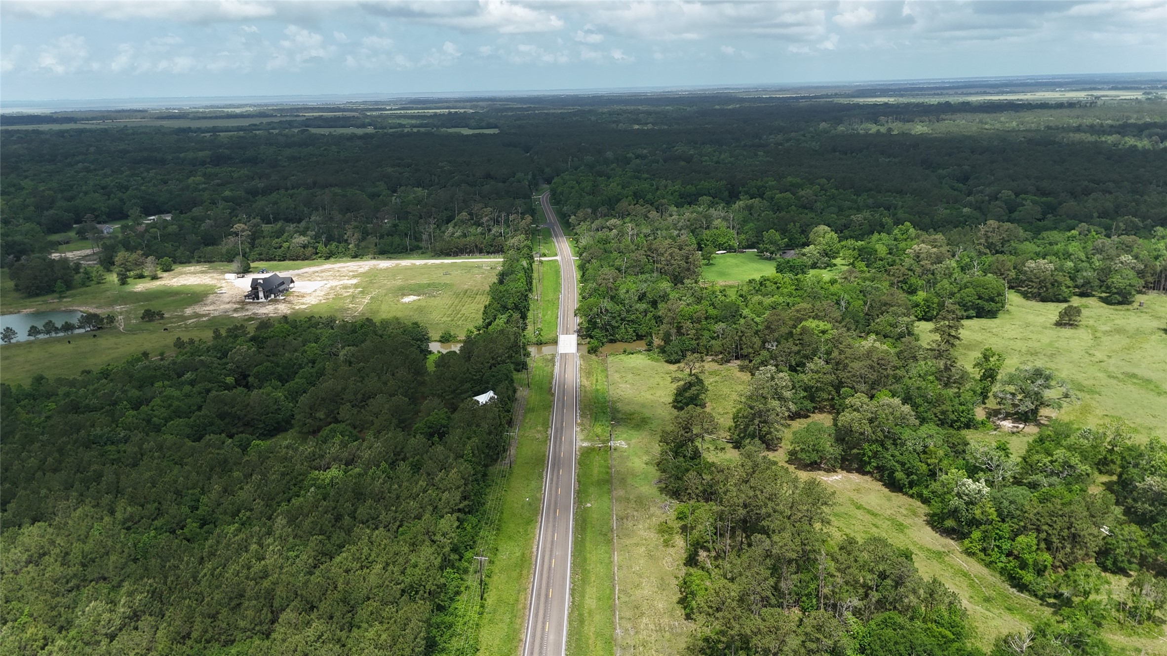 7644 Fm 562 Anahuac, TX 77514 - Photo 4 of 9 The FM round county maintained shows you the lush greenery and dense forest.
