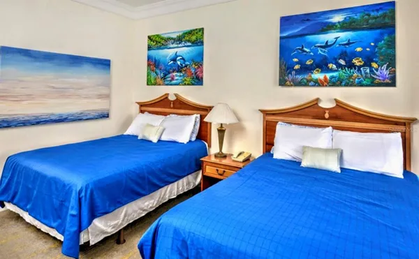 a bedroom with a bed and painting on the wall