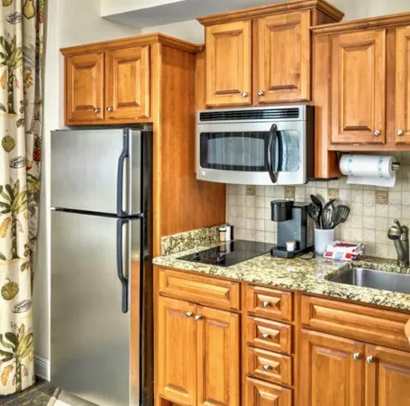 a kitchen with stainless steel appliances granite countertop a refrigerator and a sink
