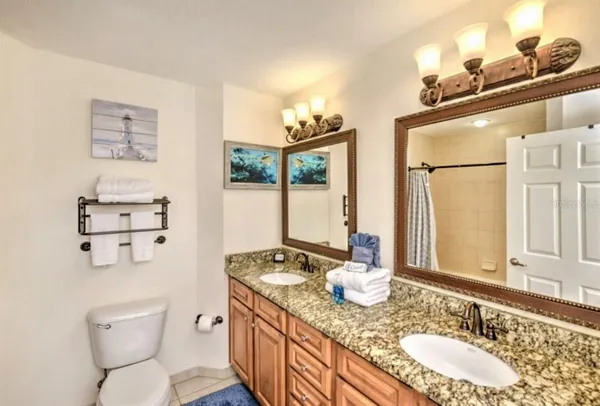 a bathroom with a granite countertop toilet sink and mirror