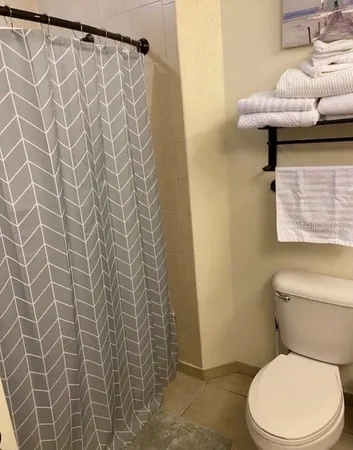 a bathroom with a toilet and a shower curtain