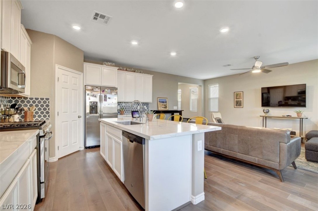 6920 Fossil Rim Street North Las Vegas, NV 89084 - Photo 3 of 9 An open concept kitchen and living area, featuring an island with seating.