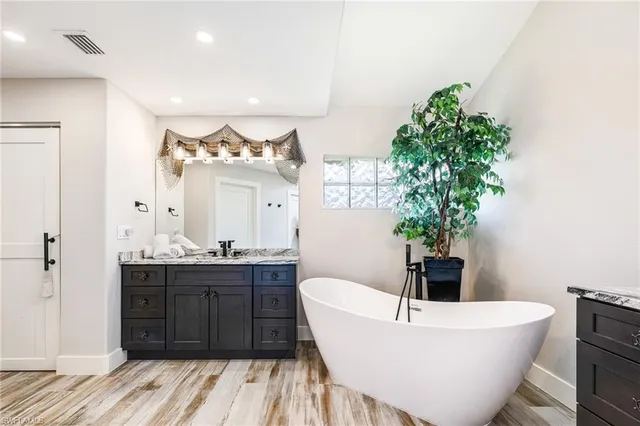 a dining room with furniture large windows and wooden floor