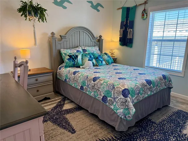 a bedroom with a bed and a mirror on the dresser