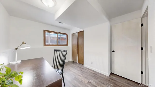 a view of a hallway with wooden floor and a bedroom