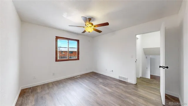an empty room with wooden floor and window